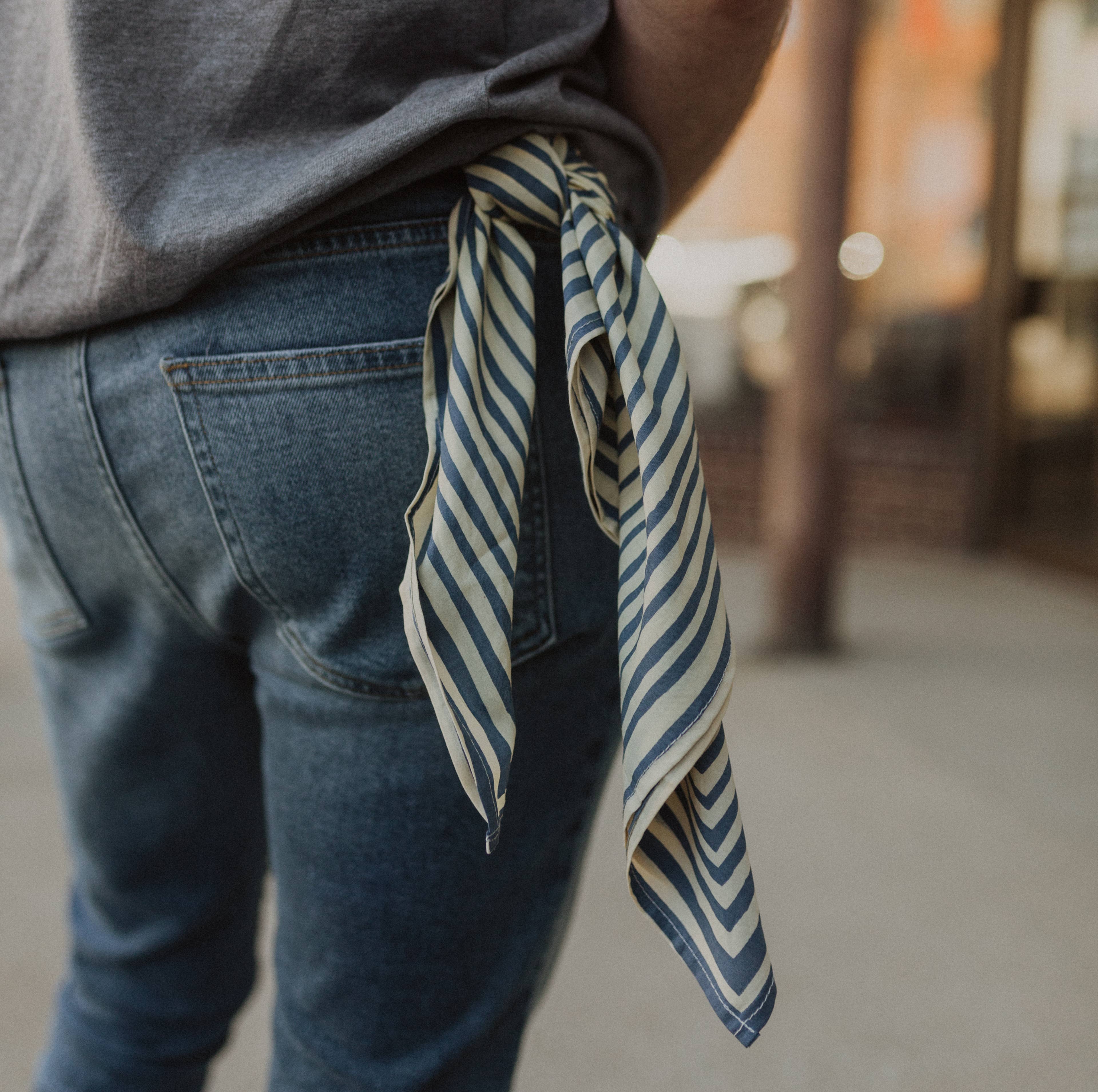 Person wearing a striped scarf over their shoulder with a blurred background