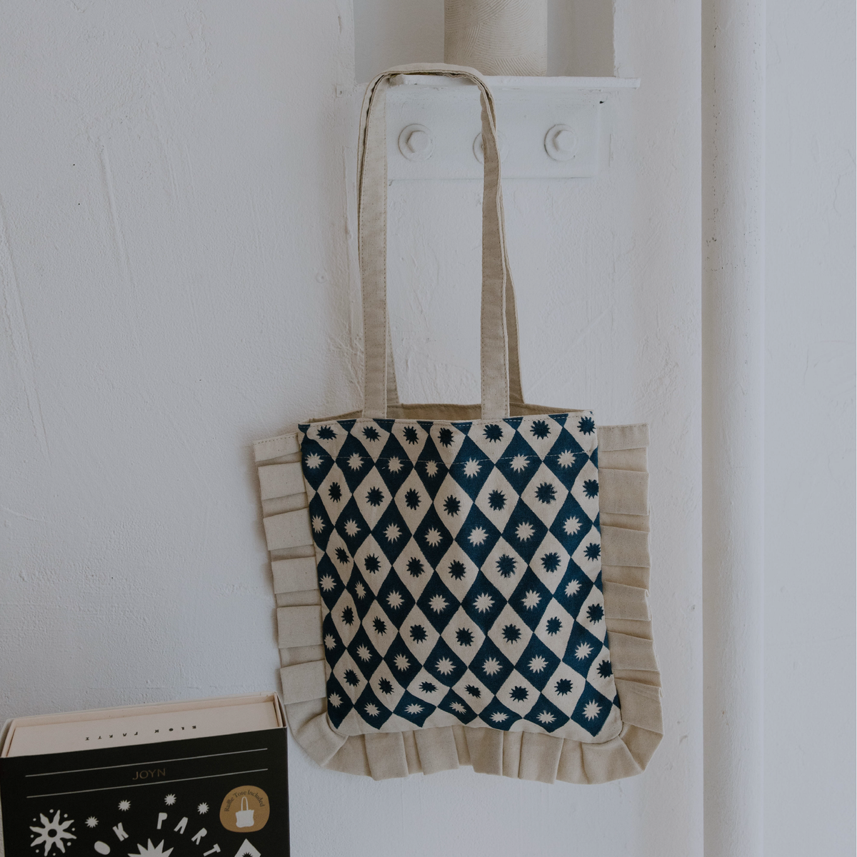 Tote bag with geometric pattern hanging on a white wall