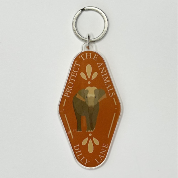 Red/Orange diamond shaped keychain with an elephant. Reading "Protect the animals" and "Dilly Lane"