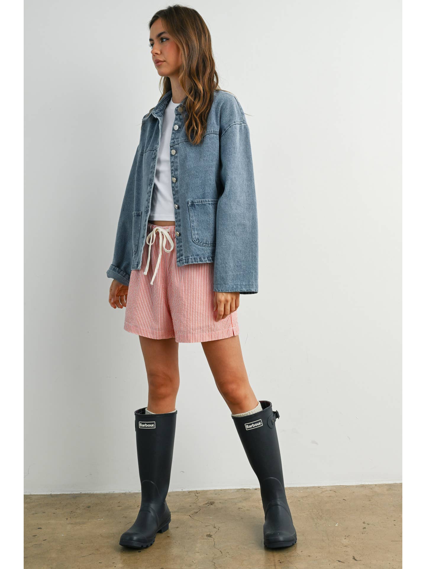 Medium wash denim jacket with silver buttons, box pockets, and collar. 