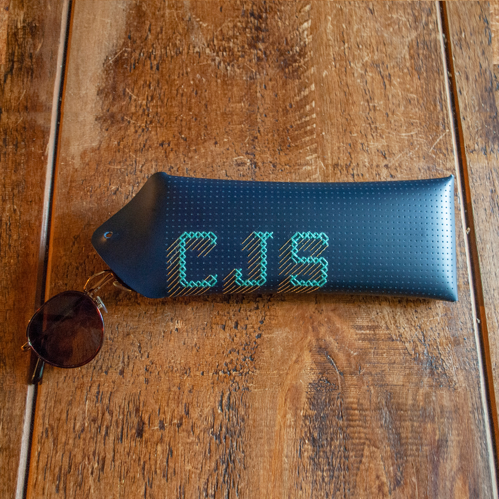 Stitch your own way - this envelope pocket is ideal as a pencil or glasses case and allows you to sew any unique design. Whether you stitch initials, a slogan or the sunglasses template included, it opens out fully for easy stitching. It also opens 2 ways, so it can open from the side or from the top - just pop the metal buttons to fold up whichever way you prefer. The Navy pouch comes with teal & gold thread &amp; needle wrapped on our pen thread-board. It includes our 3D alphabet template to add initials