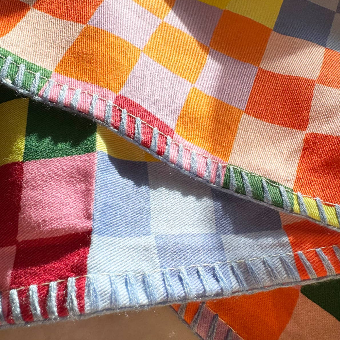 Close-up of a colorful checkered fabric with a visible seam.