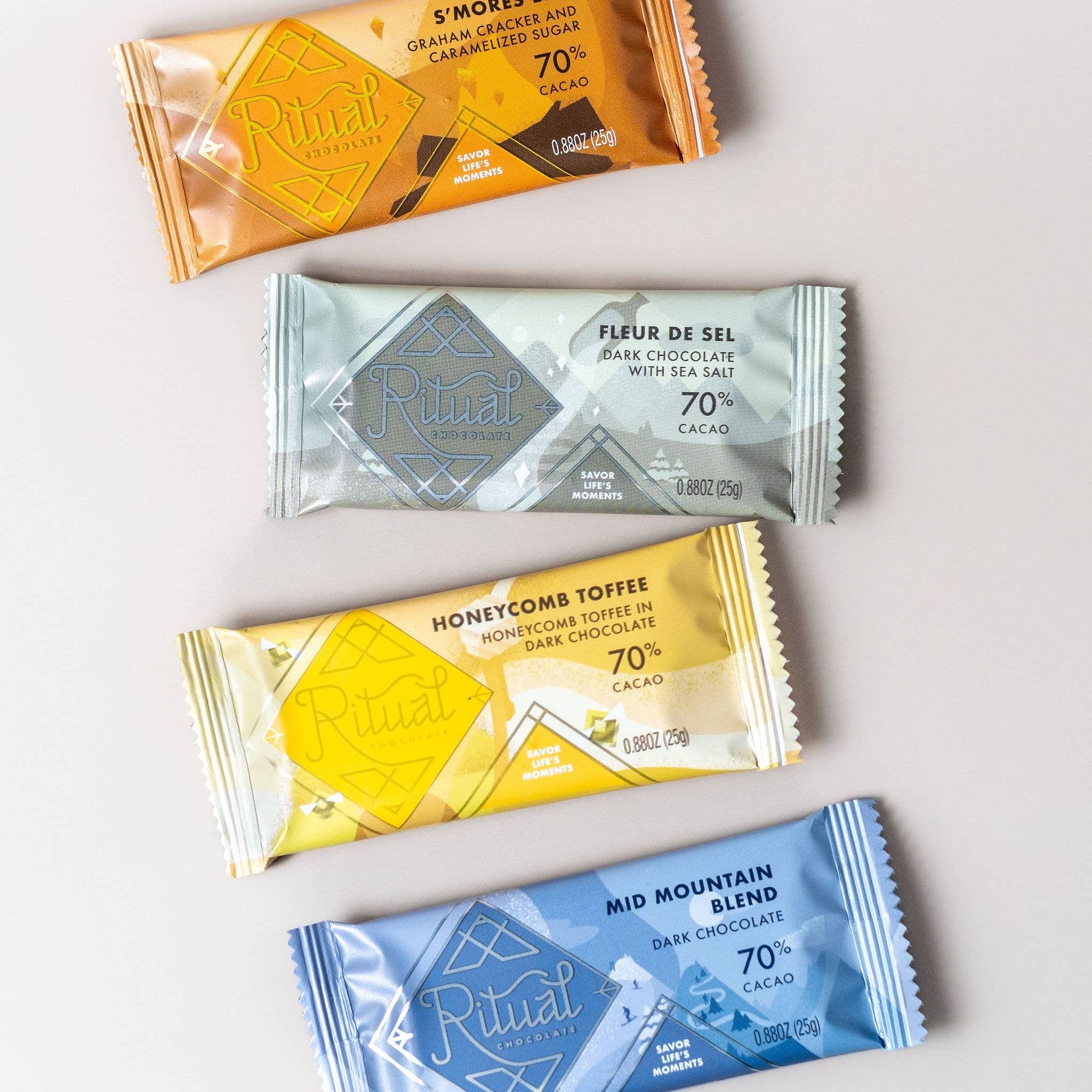Four different chocolate bars with colorful packaging on a light gray background
