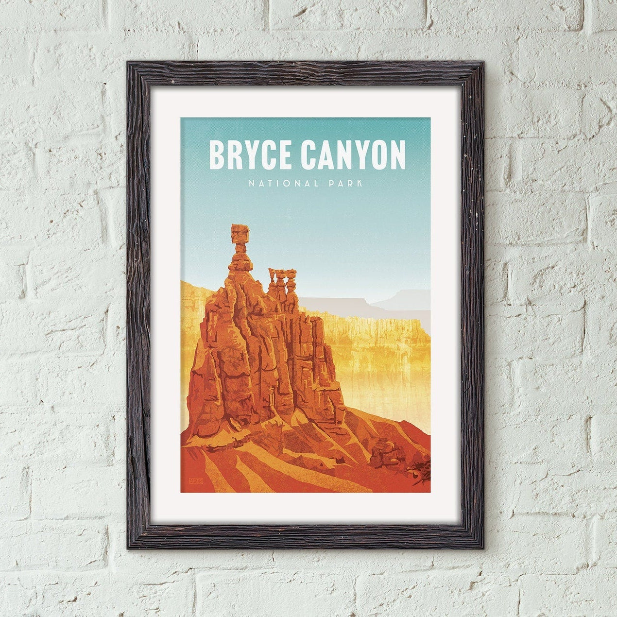 Framed poster of Bryce Canyon National Park on a white brick wall