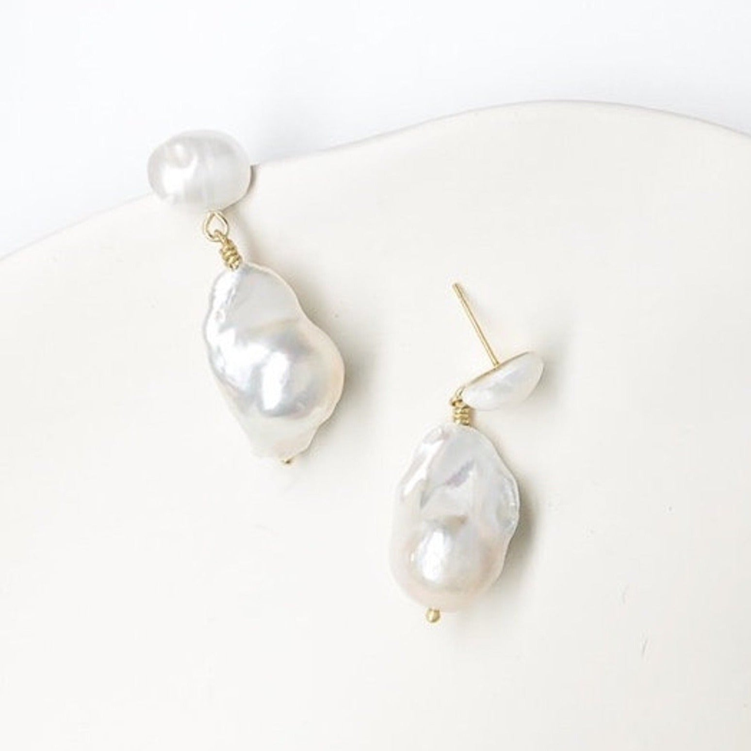 Elevate your accessory game with these natural pearl and gold plated ear posts. Enhance your ensemble with a touch of elegance and shimmer. Embrace nature's beauty and let your ears make a statement.