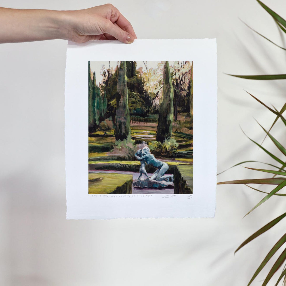 A well manicured stately garden with an iron statue of a woman and child embracing. 