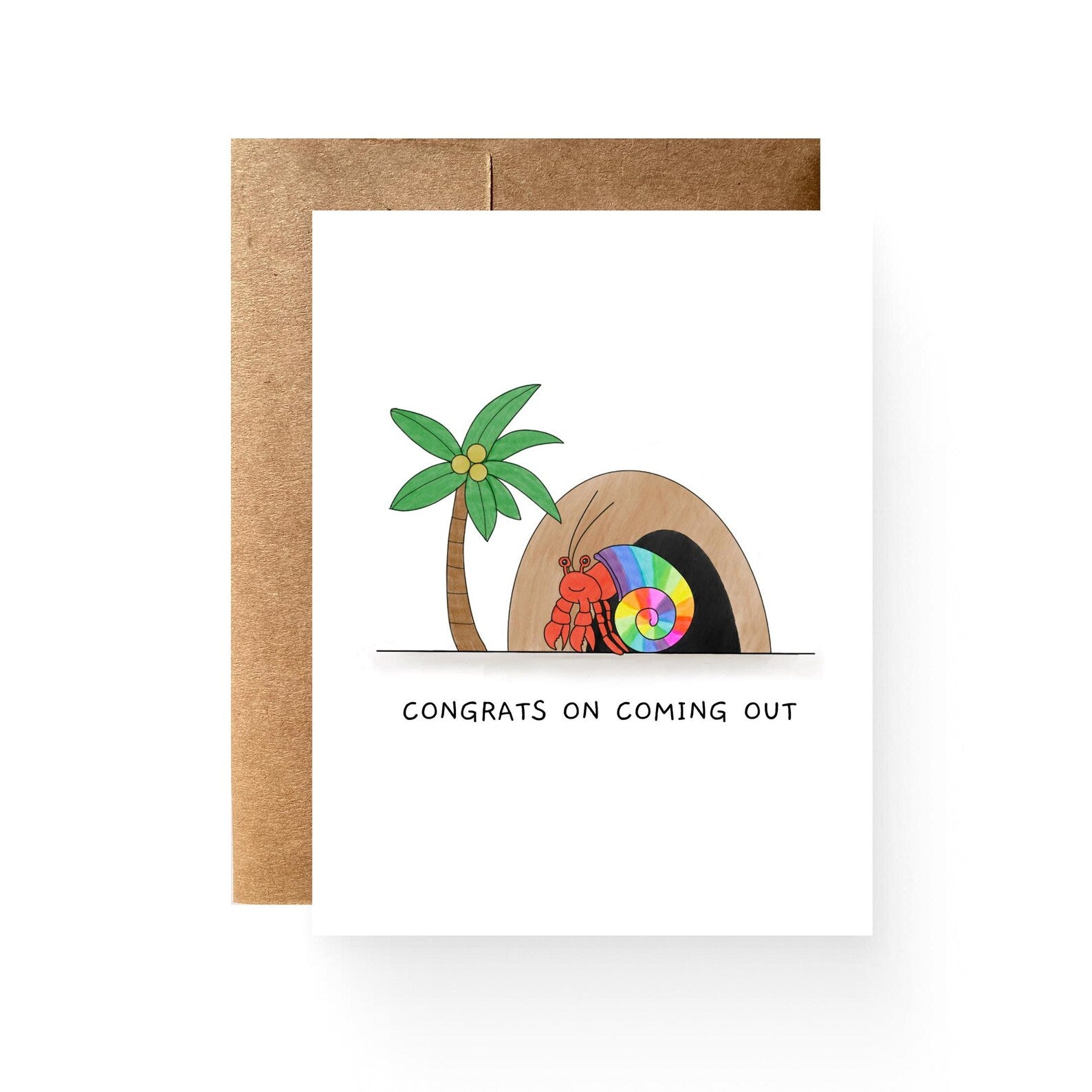 white card with a cave, palm tree, and hermit crab with a rainbow shell. reading "congrats on coming out"