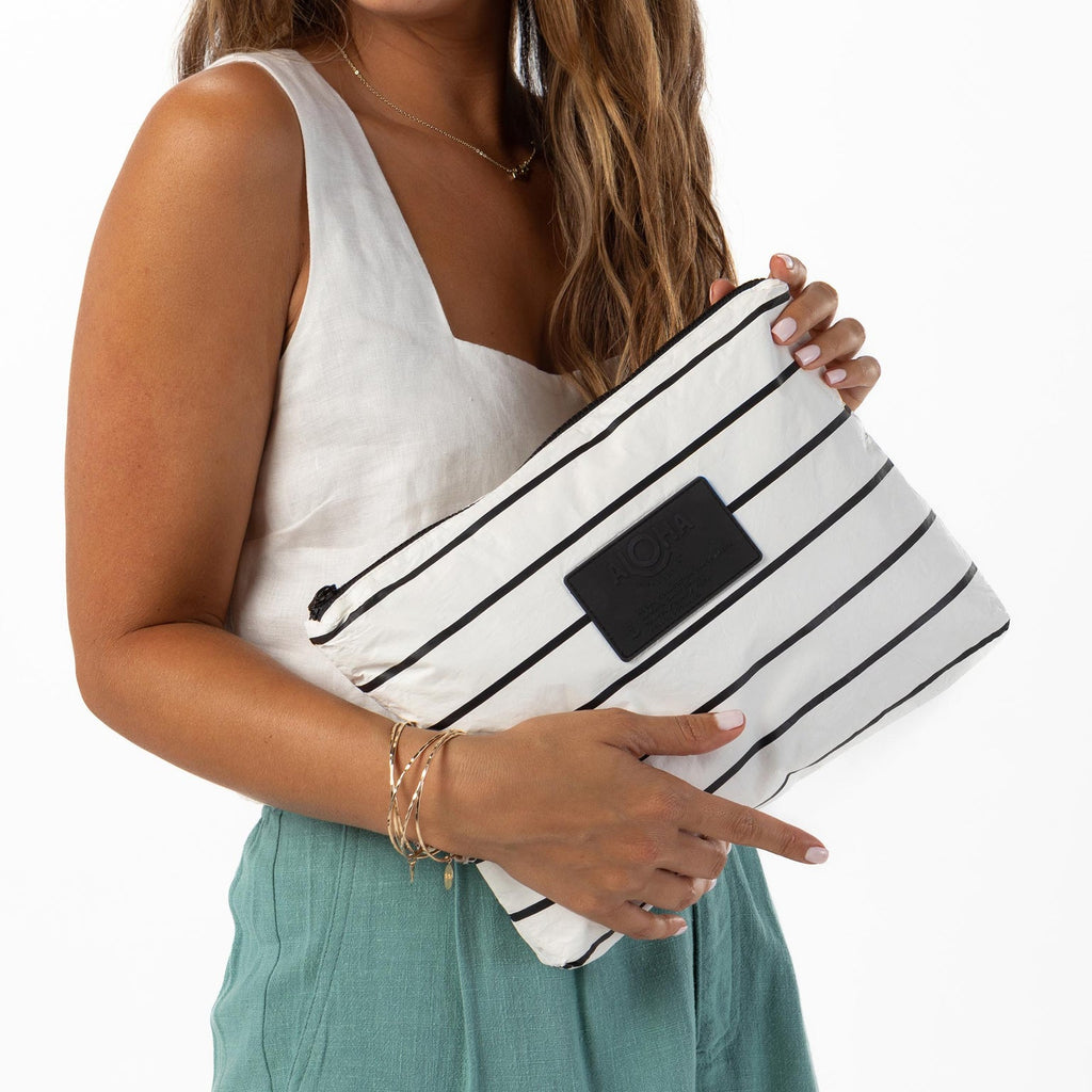 This black/white multi-tasking Mid pouch is an excellent option for travel. Use it to stow accident-prone toiletries to eliminate leaks from happening inflight. You can also use it to pack tech and travel gear to keep your carry-ons organized and items like chargers and power cords within reach. Packing for a beach day? Toss in sunscreen, sunnies, pareo, book, a comb, and your coverup inside.