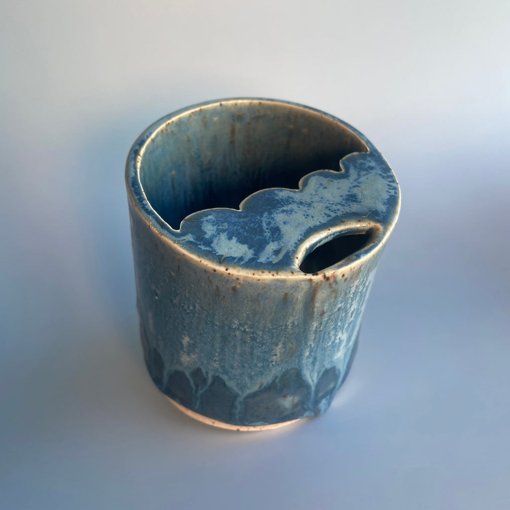 blue ceramic travel cup with a scalloped sipper top