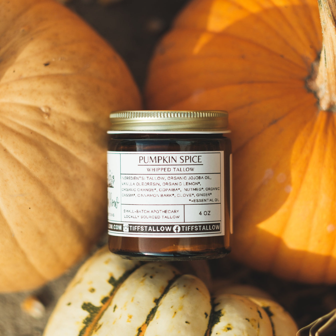 4oz jar of Pumpkin Spice Tallow pictured against rustic pumpkins.