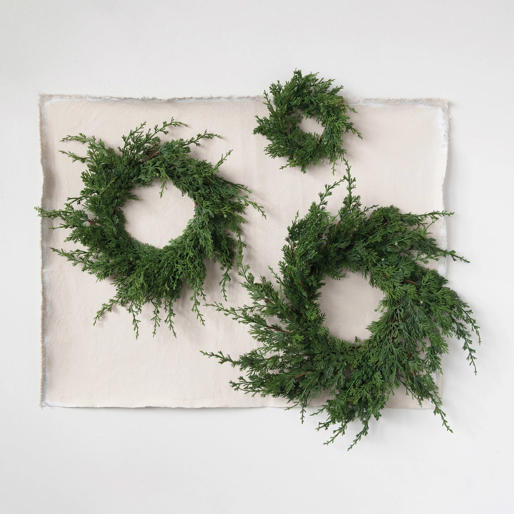 This wreath is a great first impression for any festive home. Made out of faux juniper, this wreath is both simple and classic. This piece effortlessly welcomes anyone entering your home in a festive way, and adds a pop of style to any door     Dimensions  4-1/2"  Round