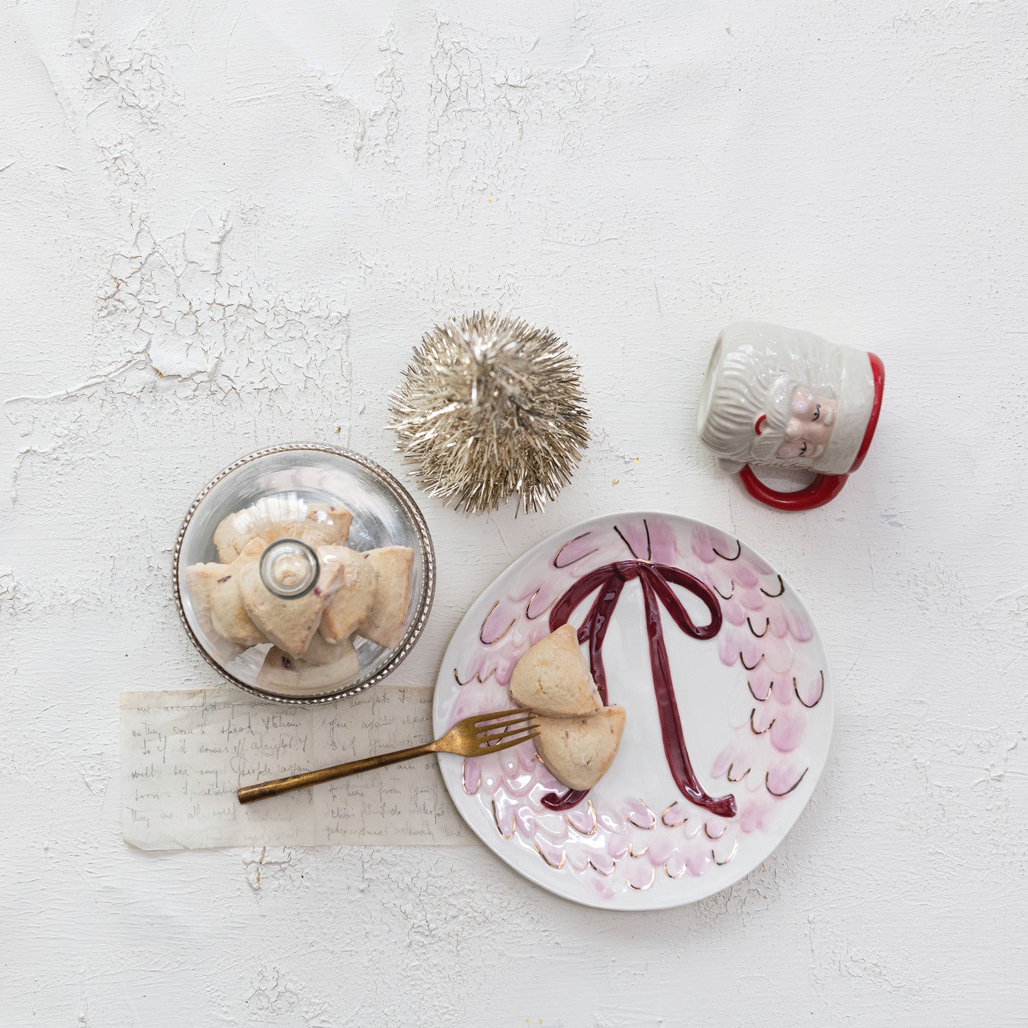 Table setting with a decorative plate, mug, and small dish on a light gray surface.
