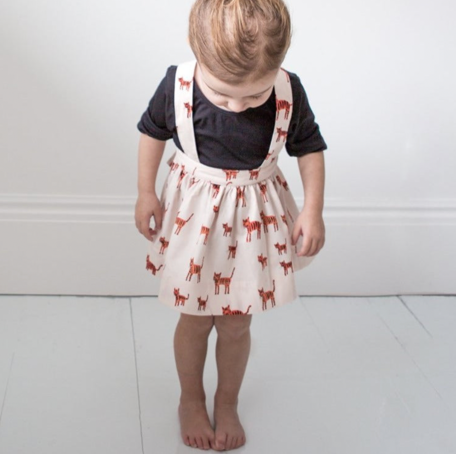 The Andi mini trouser skirt has adjustable suspenders with a button on the back. Two button holes are sewn on each suspender strap so your child can grow with their skirt making it easy to wear high on her waist when they are younger &amp; on their natural waist when older