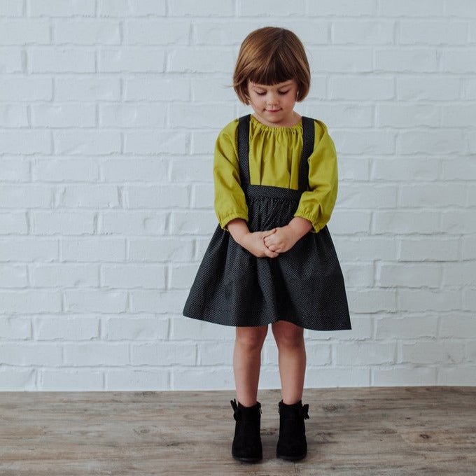 The Andi mini trouser skirt has adjustable suspenders with a button on the back. Two button holes are sewn on each suspender strap so your child can grow with their skirt making it easy to wear high on her waist when they are younger &amp; on their natural waist when older